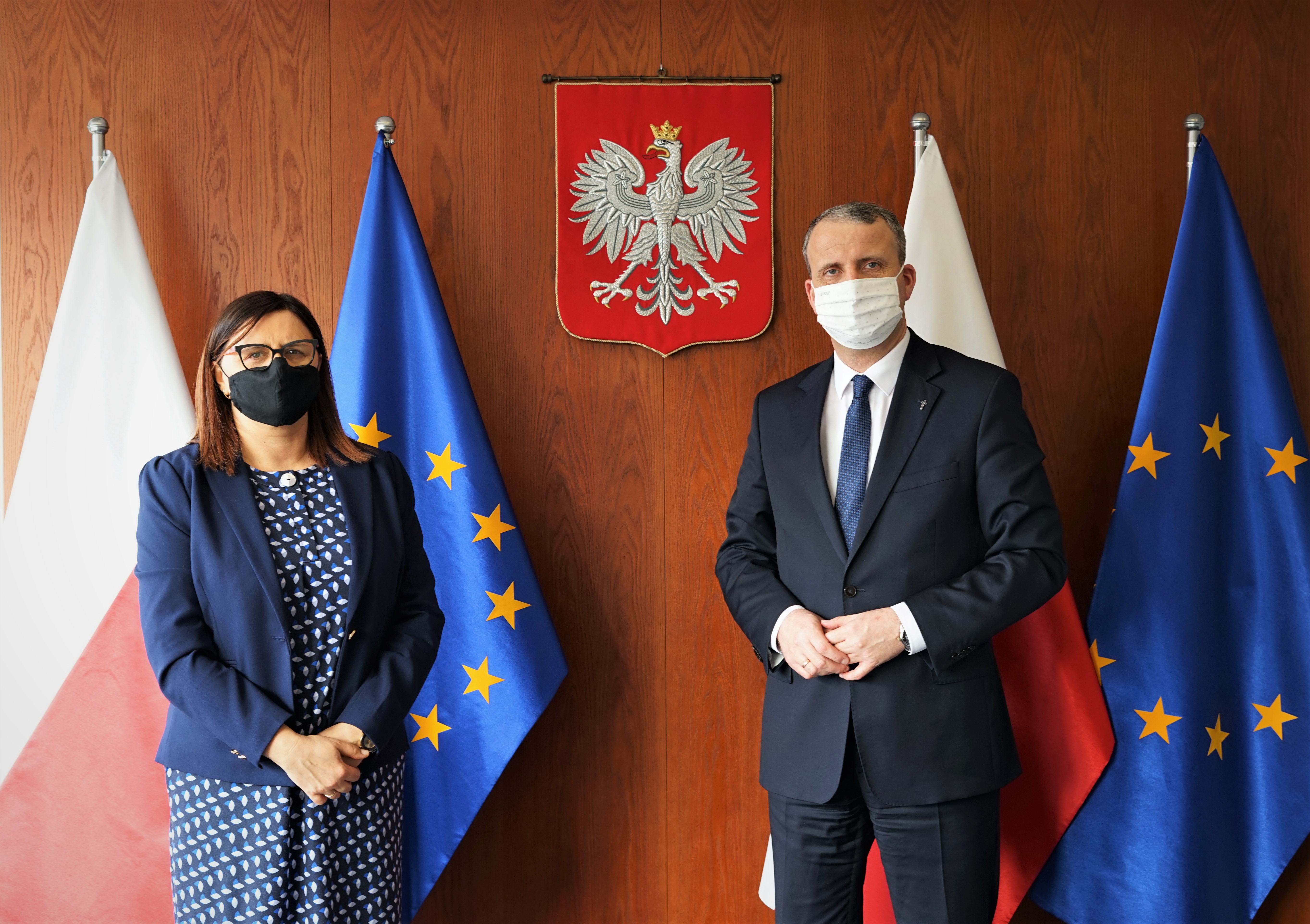 Starosta Beata Hanyżak z Wojewodą Michałem Zielińskim na tle flag Polski i Unii Europejskiej. W tle widoczne również godło.