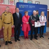 Poseł na Sejm RP Marta Kubiak, Poseł na Sejm RP Krzysztof Czarnecki, Wojewoda Wielkopolski Michał Zielińsk, Wielkopolski Komendant Wojewódzki Państwowej Straży Pożarnej w Poznaniu nadbrygadier Dariusz Matczak wręczają promesę strażakowi z OSP