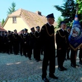 Strażacy przygotowani do pochodu wraz ze sztandarem 