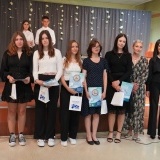 Zakończenie roku szkolnego w Zespole Szkół nr w Szamotułach, 6 uczennic  z wyróżnieniami, nauczycielka  i dyrektor  Aleksandra Lis-Łagodzińska, w tle 2 uczniów prowadzących uroczystość 