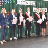 2 nauczycielki, czterech uczniów, którzy otrzymali stypendium i dyrektor Zespołu Szkół nr 1 we Wronkach na tle zielonych kotar 