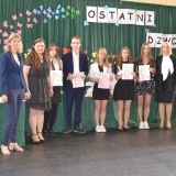 Dwie nauczycielki, 1 uczeń i 4 uczennice, którzy otrzymali stypendium i dyrektor Zespołu Szkół nr 1 we Wronkach na tle zielonych kotar 