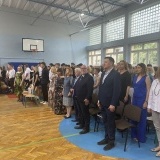 Zakończenie roku szkolnego w Zespole Szkół nr 2 w Szamotułach na pierwszym planie dyrekcja i nauczyciele, za nimi uczniowie szkoły na sali gimnastyczneh