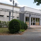 Odnowione wejście do szkoły i hali sportowej, pomalowane ściany na kolor biały i szary 