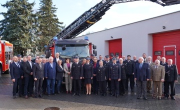 Goście wraz z nowym ciężkim samochodem ratowniczo-gaśniczym przed Komendą Powiatową Państwowej Straży Pożarnej w Szamotułach