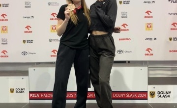 Zawodniczki Wiktoria Knutowicz i Hanna Biniakiewicz na tle podium 